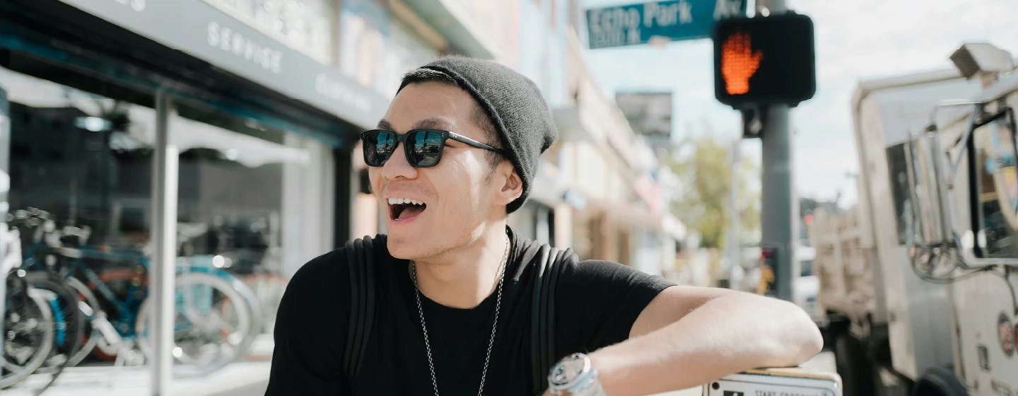 a smiling young asian american man on the streets of los angeles