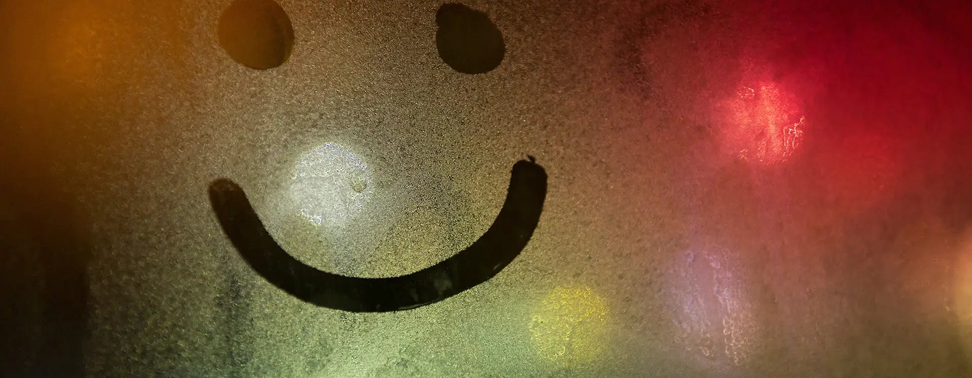 Smiley face drawn on a condensed window